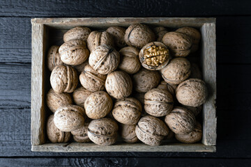 Walnut nuts in a wooden box on old wooden table lose up. Food photography
