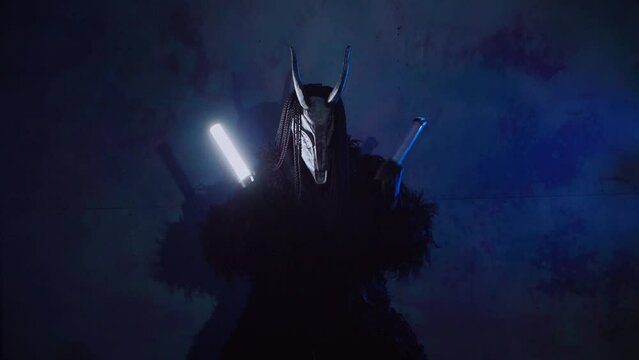 The devil monster dances with RGB sticks in his hands. A mystical man in a scary mask in a dark studio. The man is dressed in a black coat and a mask with horns on his head. Alien from space. Horror,