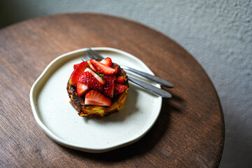 Close up delicious strawberry cheesecake in plate on wooden table.