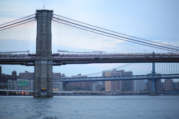  Brooklyn Bridge in front of Manhattan Bridge crossing the East River in the evening
