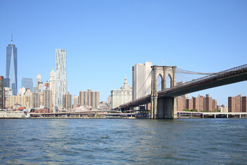 Coast Manhattan with lots of skyscrapers and a pier with Brooklyn Bridge