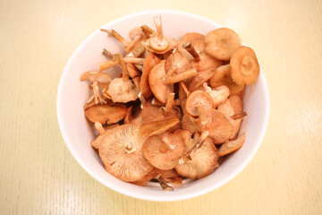 Raw fresh Honey mushrooms in white plate on wooden table