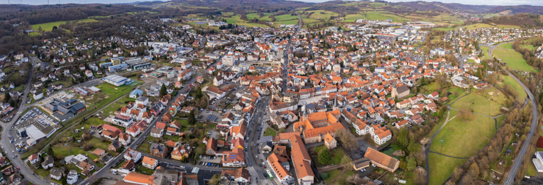 Aerial around the old town of the city Schlüchtern in Hesse, Germany on a sunny day day in winter	