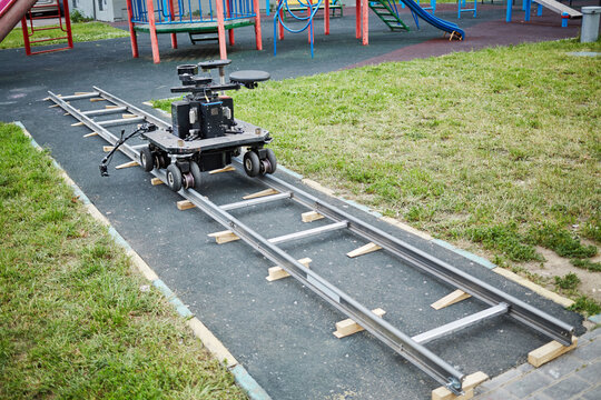 Cameraman dolly stands on rails mounted at children playground