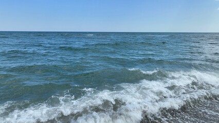Fototapeta na wymiar Ocean wave breaking in surf by the beach on a warm summer day
