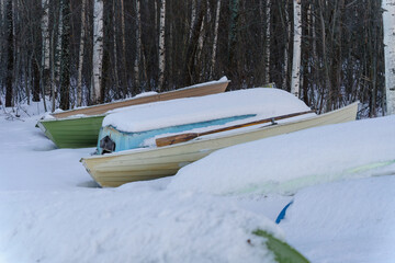 Snow covered rowboats on a beach