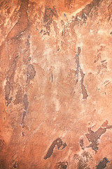 Ragged red-brown wall with cracked plaster