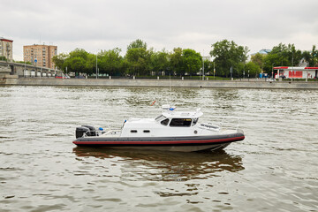Patrol boat on river in city on summer day