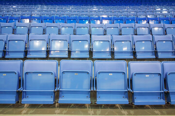 Many rows of blue empty seats with numbers in big modern sport stadium