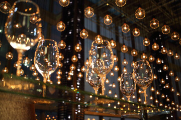 Wine glasses on a glass countertop illuminated lots of luminous lamps