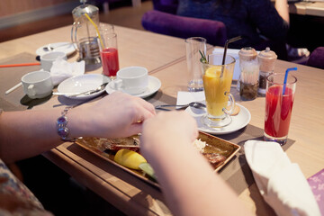 Female hands above plate with food on table in cafe