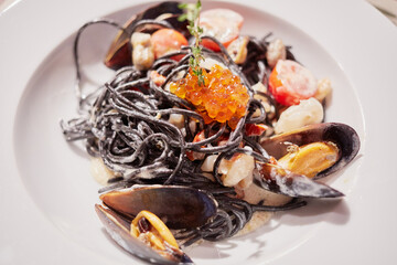 Mussels, red caviar and vegetables mix on white plate