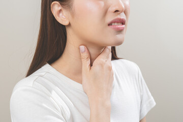 Sickness in inflaming asian young woman, girl use hand check self touch at sore throat, pain...