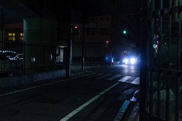夜の街の風景、車のヘッドライトが夜の街の道路に光る