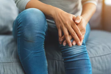 Foto op Plexiglas Managing Knee Pain: Woman with Arthritis Resting at Home. Generative AI. © Cevko