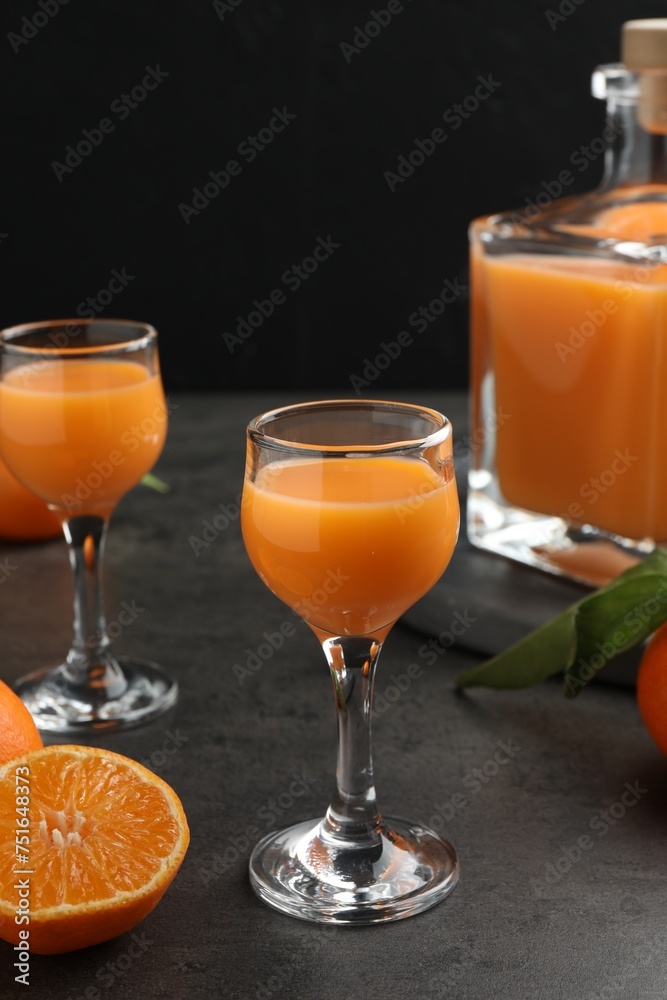 Wall mural Delicious tangerine liqueur and fresh fruits on grey table