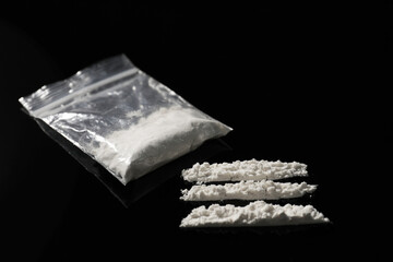 Drug addiction. Plastic bag with cocaine on black table