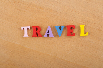TRAVEL word on wooden background composed from colorful abc alphabet block wooden letters, copy space for ad text. Learning english concept.