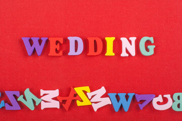 WEDDING word on red background composed from colorful abc alphabet block wooden letters, copy space...