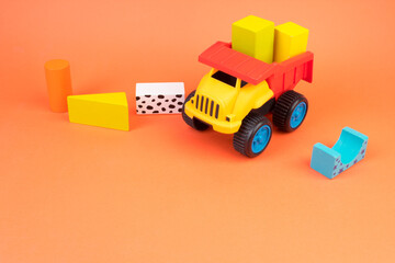 Top view of colorful wooden bricks on the table. Early learning. Educational toys on a orange background.
