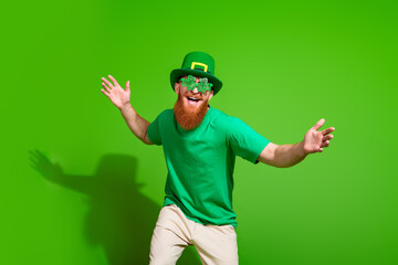 Portrait of charismatic cheerful irish man shamrock shape glasses dancing clubbing isolated on...