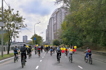 Bike ride in honor of city of Moscow,cyclists with yellow and red balloons, view from back