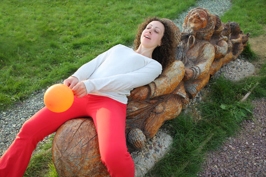 Woman with balloons and wooden characters from the fairy tale Turnip in Russian park