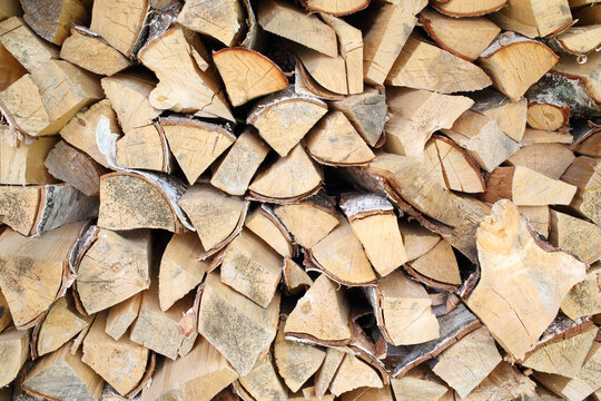 Neatly stacked birch firewood in woodpile, background