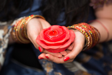 Womans hands with bracelets hold unlit candles in form of roses, Close up