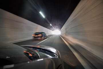 View at illuminated tunnel from right side of moving car.