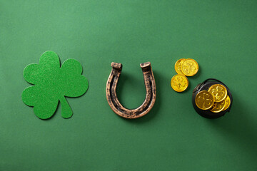 St. Patrick's day concept with clover leaf, golden coins and horseshoe on green background. View...