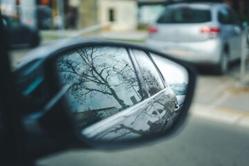Reflection of the city and trees in the side mirror of a car, abstract city travel concept - 751666766