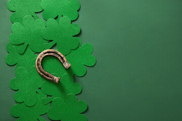 St. Patrick's day border with clover leaf and horseshoe on green background. View from above. Copy...
