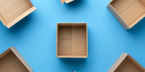 Several open boxes are placed on a smooth blue surface. The boxes are empty and show no signs of damage or wear. The blue background enhances the simplicity of the scene.