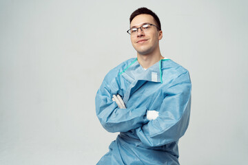 Confident medical professional in blue scrubs poses with arms crossed, symbolizing expertise and reliability in healthcare.