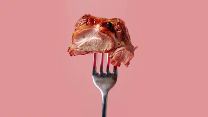 Foto op Aluminium pink background, fork holding up juicy pork roast © Xabi