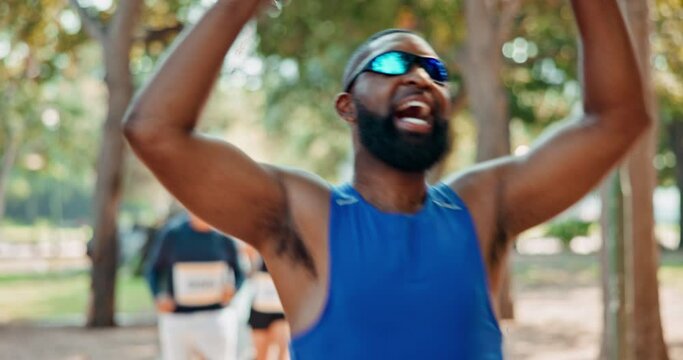 Fitness, celebration or sports runner at the finish line with arms raised for victory, achievement or exercise goals. Winning event, fast or happy man excited by running, marathon training or workout