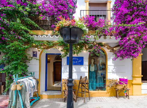 SPAIN, MARBELLA, 25, MAY, 2023: External view of the clothes shop El Desván de Lulú surrounded by flowering trees in Marbella, Spain