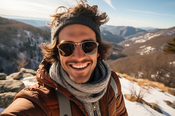 Fototapeta na wymiar Exuberant young man taking a selfie on a mountain trail in winter.