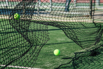 Tennis ball and net on court, showcasing movement and energy.
