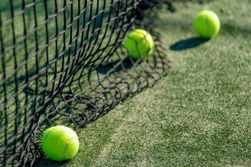Tennis balls and net on green court.