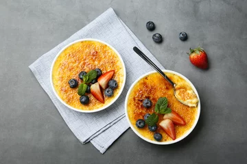 Fensteraufkleber Delicious creme brulee with berries and mint in bowls on grey table, flat lay © New Africa