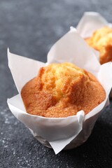 Delicious sweet muffins on black textured table, closeup