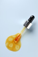 Pipette and moisturizing serum on light grey background, top view