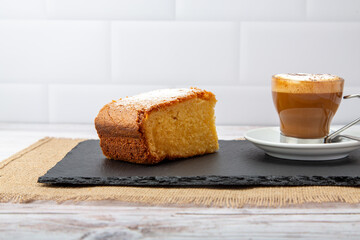 A steaming cup of coffee paired with a delectable slice of cake, a delightful blend of warmth and sweetness.
