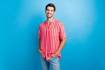 Photo of cheerful positive man dressed striped shirt smiling walking isolated blue color background