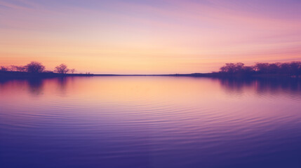 Serene sunset over tranquil lake: Peaceful sunset casting purple and orange hues over calm waters with silhouetted trees