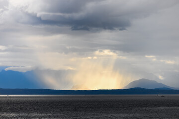 Large storm over the ocean with stormy clouds and mountains