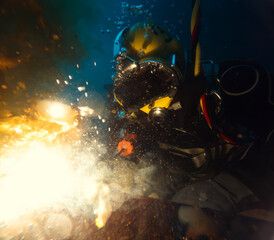 Commercial diver welding underwater at construction site - 751706372