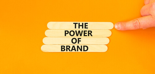 The power of brand symbol. Concept words The power of brand on wooden stick. Beautiful orange table...